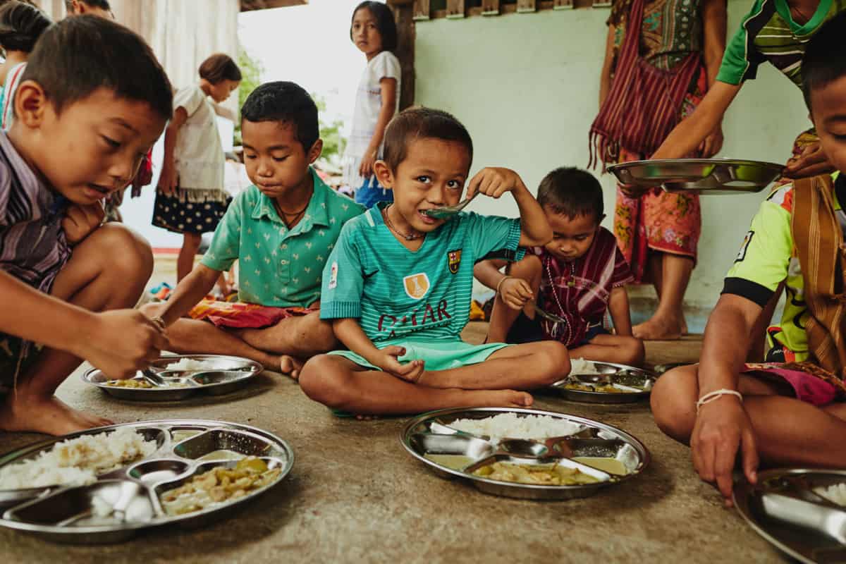 Kids in Thailand enjoy a plate of sticky rice at their Compassion center.