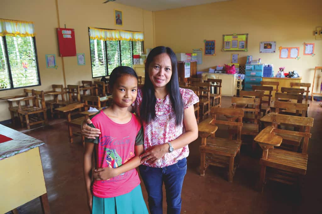 This is me with my teacher, Mrs. Lumingkit, in the classroom where I love to learn new things. Some of the other students come to class hungry because their families can’t afford food. I’m thankful to have a lunch to eat.